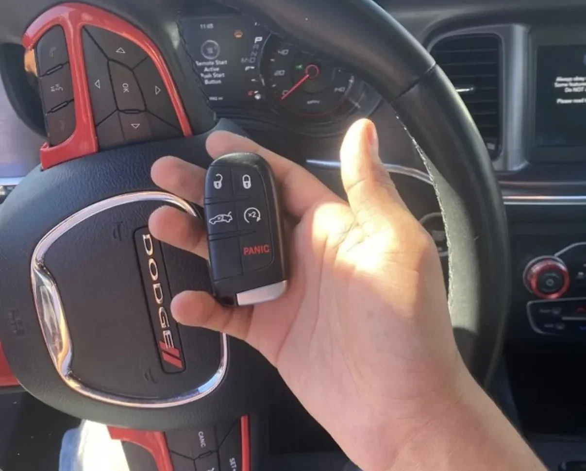 A person holding a remote control, representing automotive locksmith services.