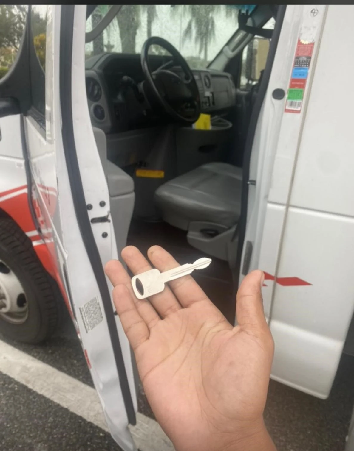 A person holding a key, preparing to unlock a van door for car key replacement.