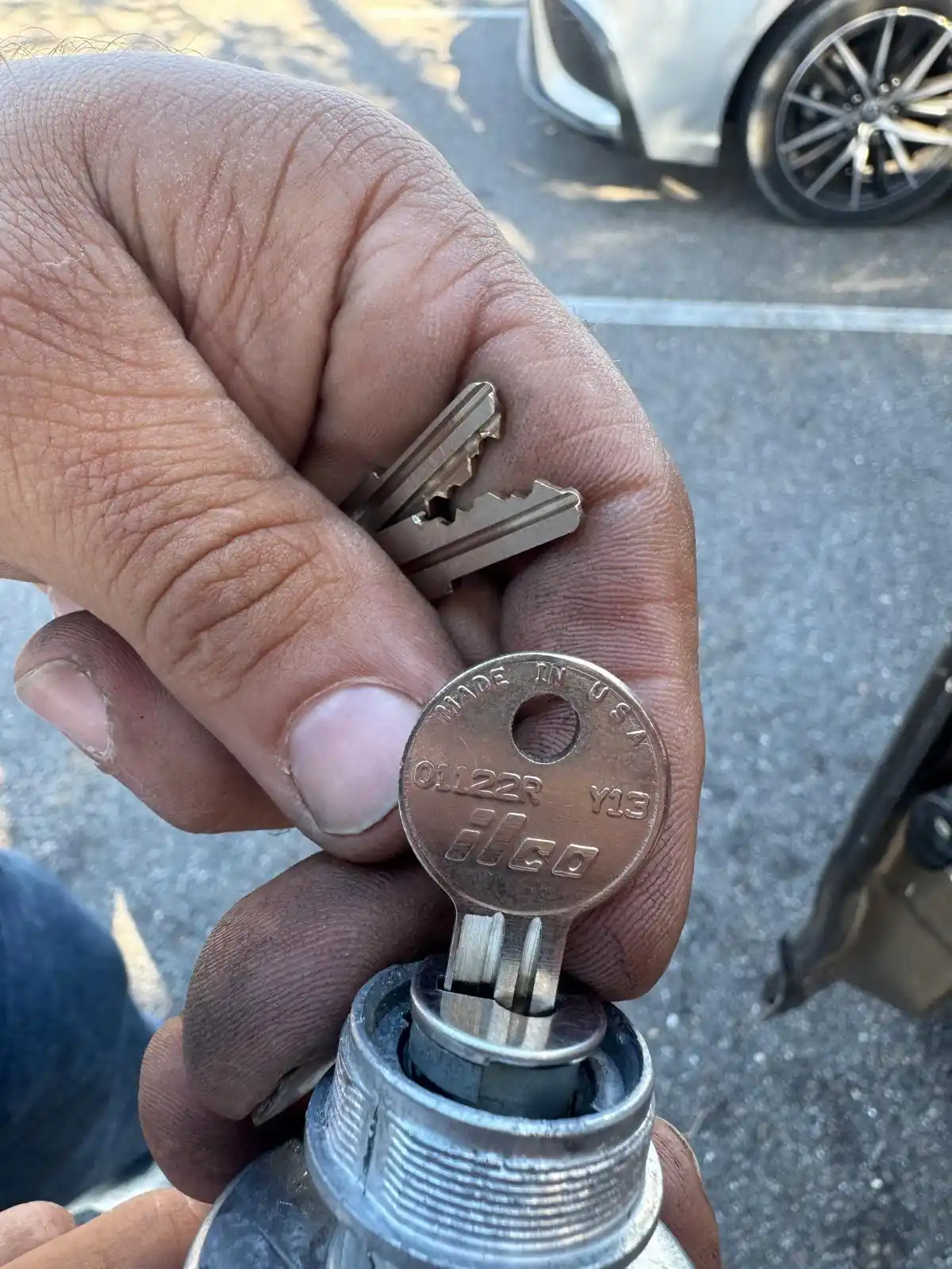 A person grabbing a car key, representing ignition repair and access to the vehicle.