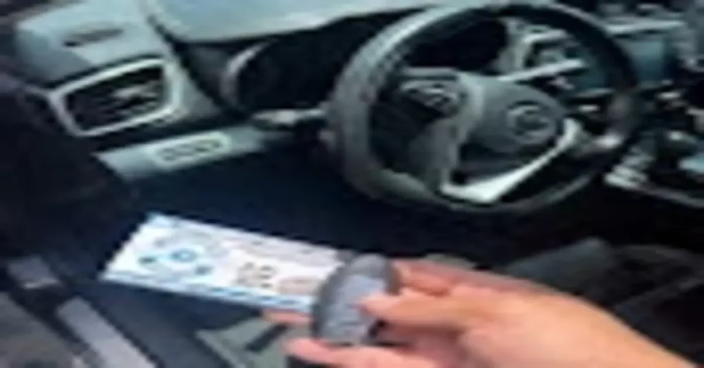 An automotive locksmith holding a key fob in a car, showcasing key replacement and programming services. The image highlights the essential role of automotive locksmiths in providing quick and efficient solutions for key and ignition issues