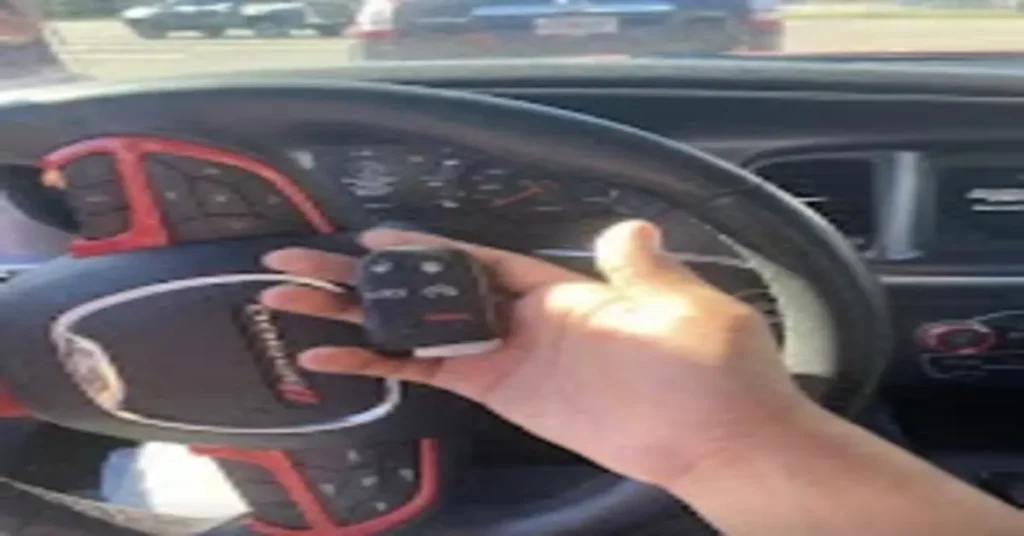 utomotive locksmith providing a key replacement service. The image shows a hand holding a key fob in front of a car's steering wheel, demonstrating the importance of hiring an automotive locksmith for key programming and car lock issues.