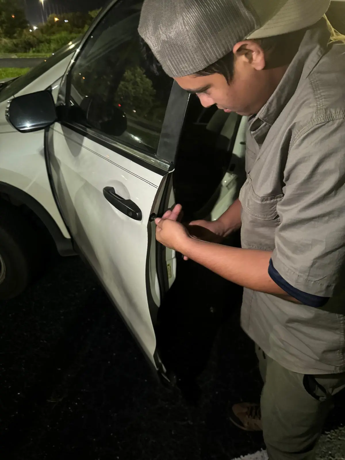 A locksmith from AA Locksmith Pasco LLC extracting a broken key from a car door lock using specialized tools, representing expert broken key extraction service.